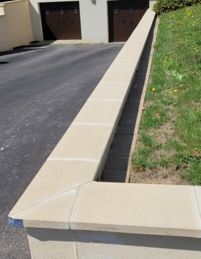 Réfection de joints entre des couvertines en béton.