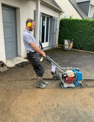 Rebouchage d'un sol en béton bitumeux après un changement de canalisation.
