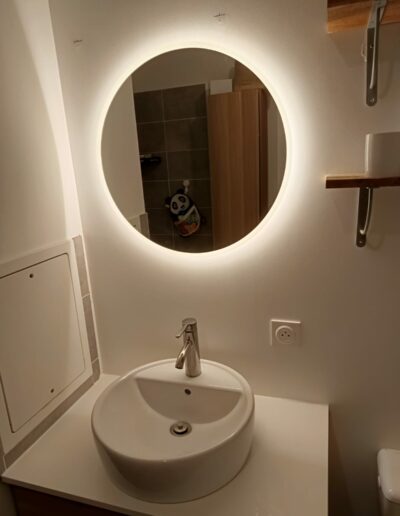 Installation d'un miroir dans une salle de bains.