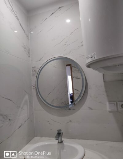 Pose d'un miroir dans une salle de bains.