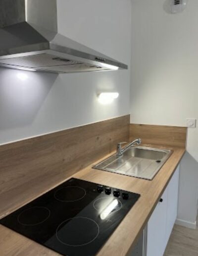 Installation d’une hotte aspirante et de plaques de cuisson dans une cuisine semi-équipée